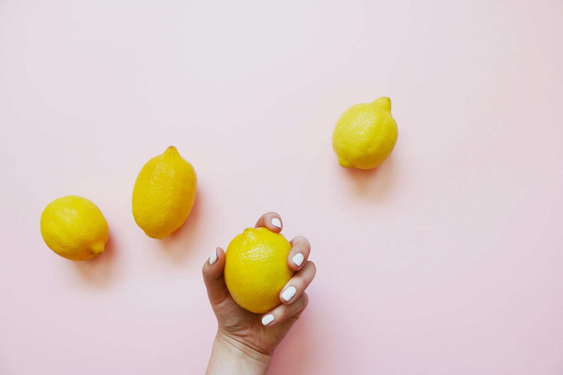 Two lemons resting on a soft pink surface, symbolizing shared pleasure and exploration