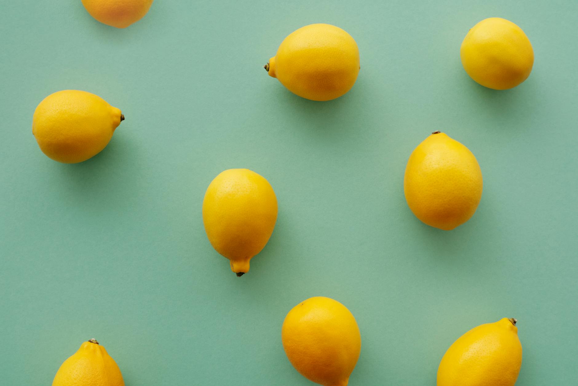 Bright yellow lemons on a pastel green background, representing the Lemon vibrator and longer, mindful arousal timelines