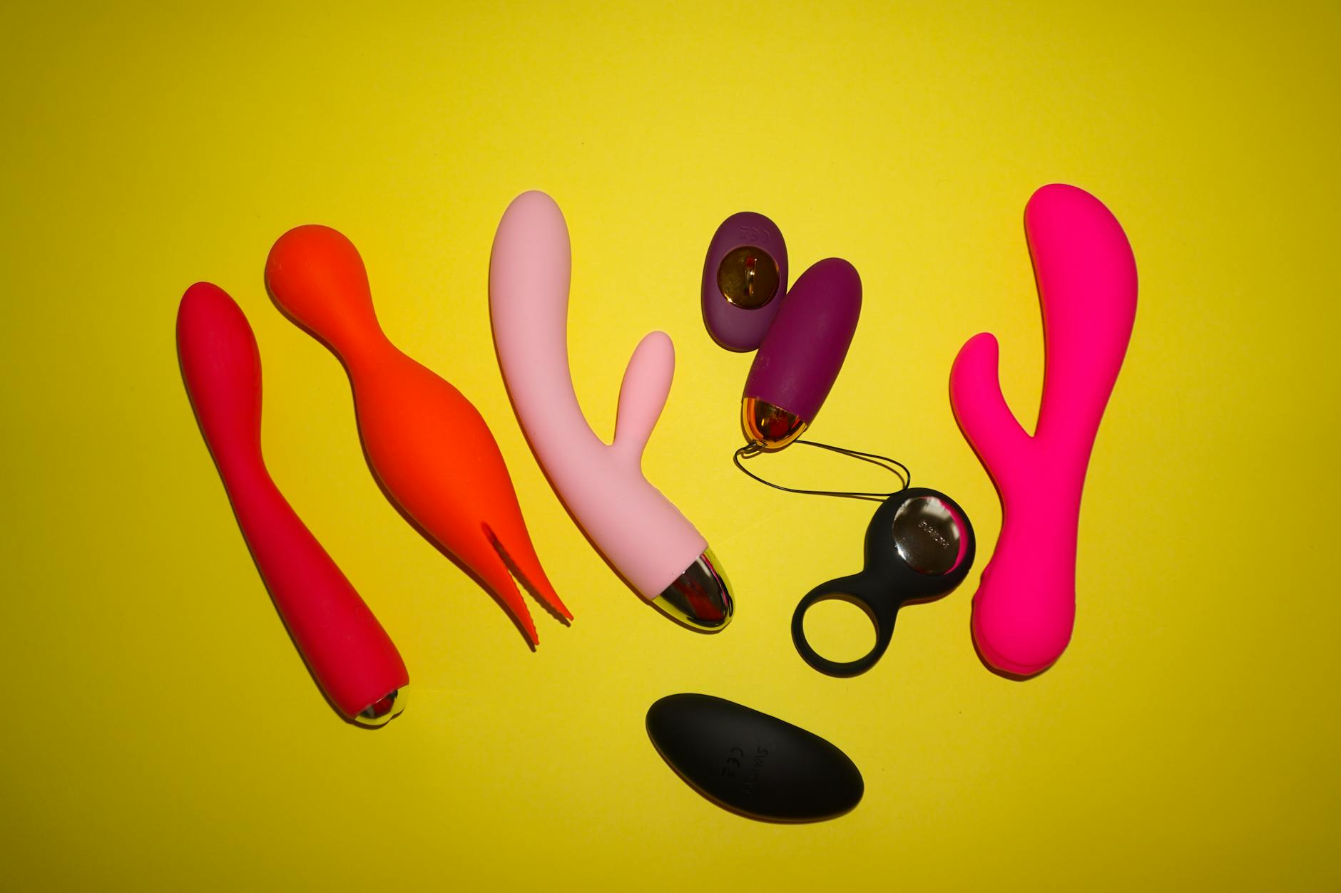 A hand holding a blue vibrator against a purple background, symbolizing healing and reclaiming pleasure