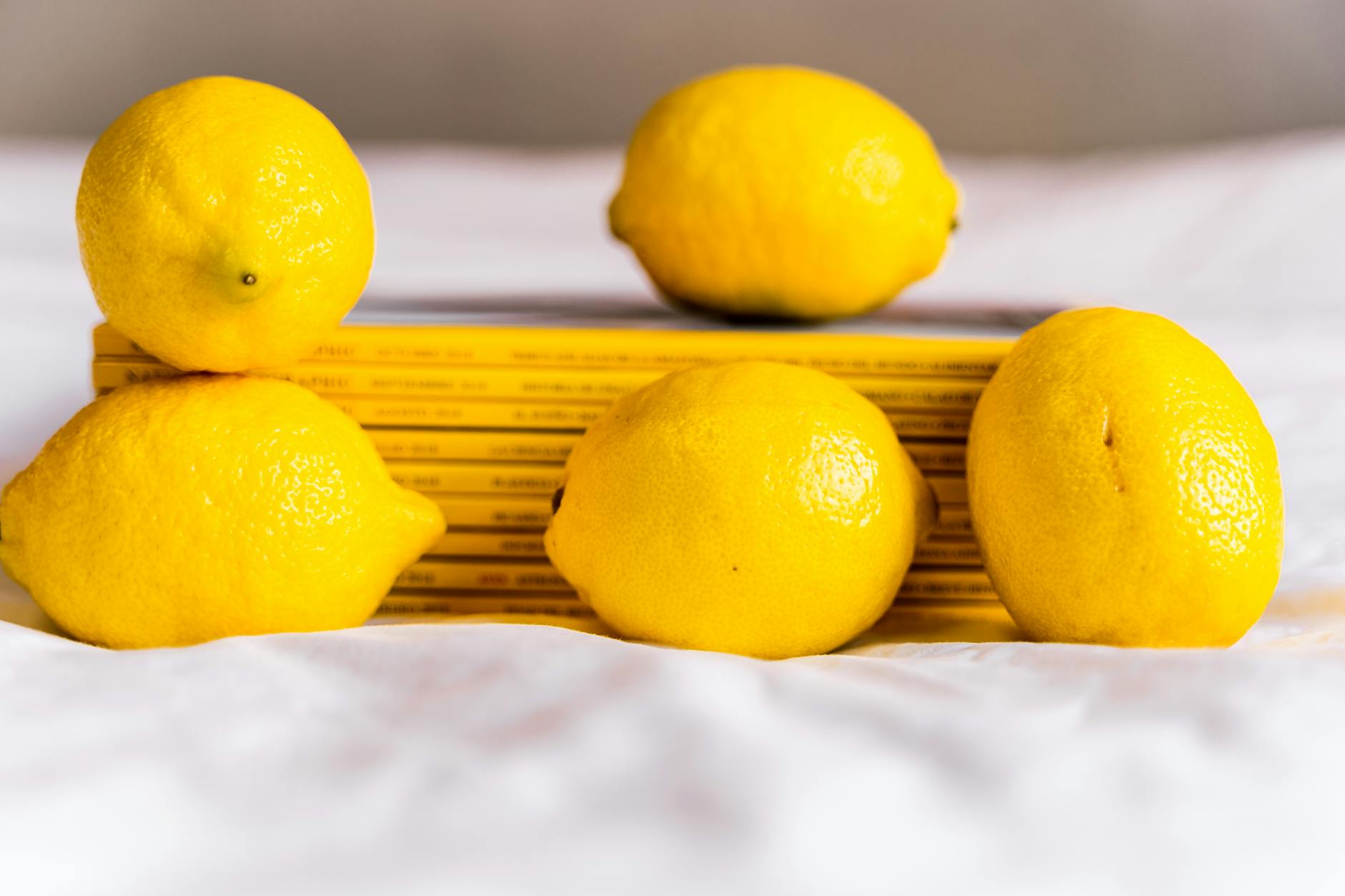 Bright lemons arranged on yellow background, representing renewal and fresh approaches to pleasure